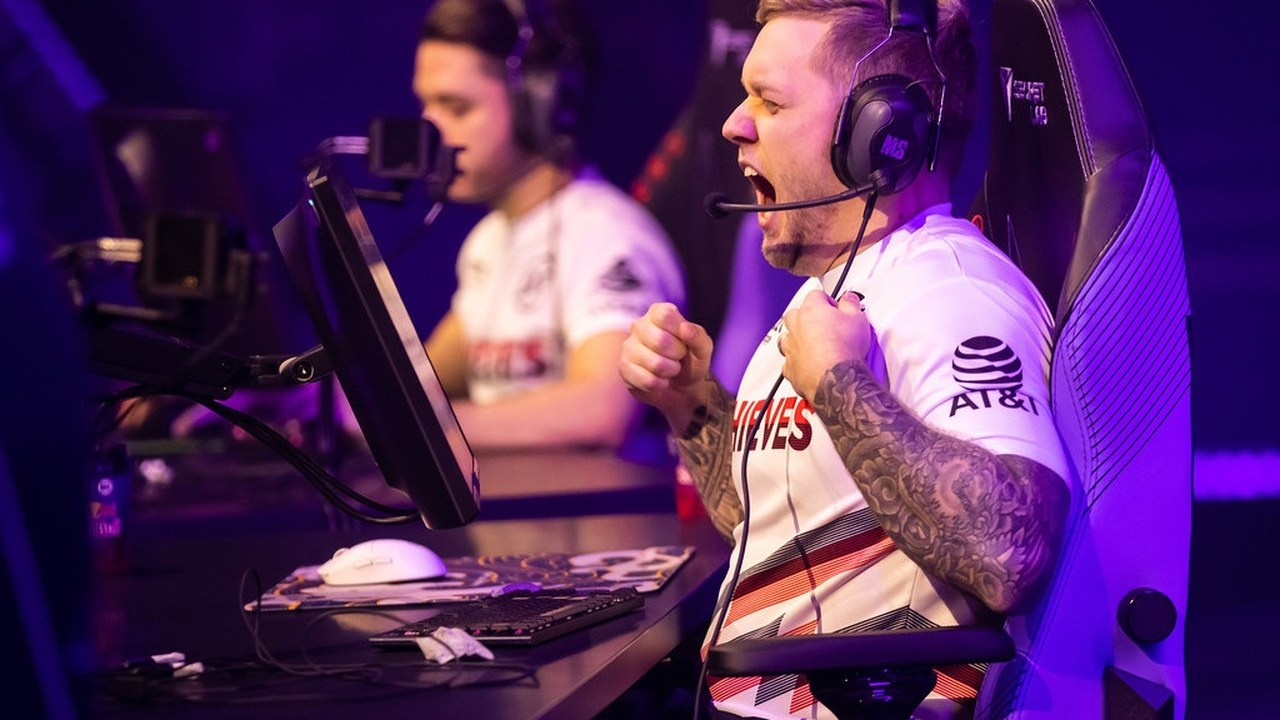 Игрок в 100 Thieves празднует победу за своим турнирным компьютером.