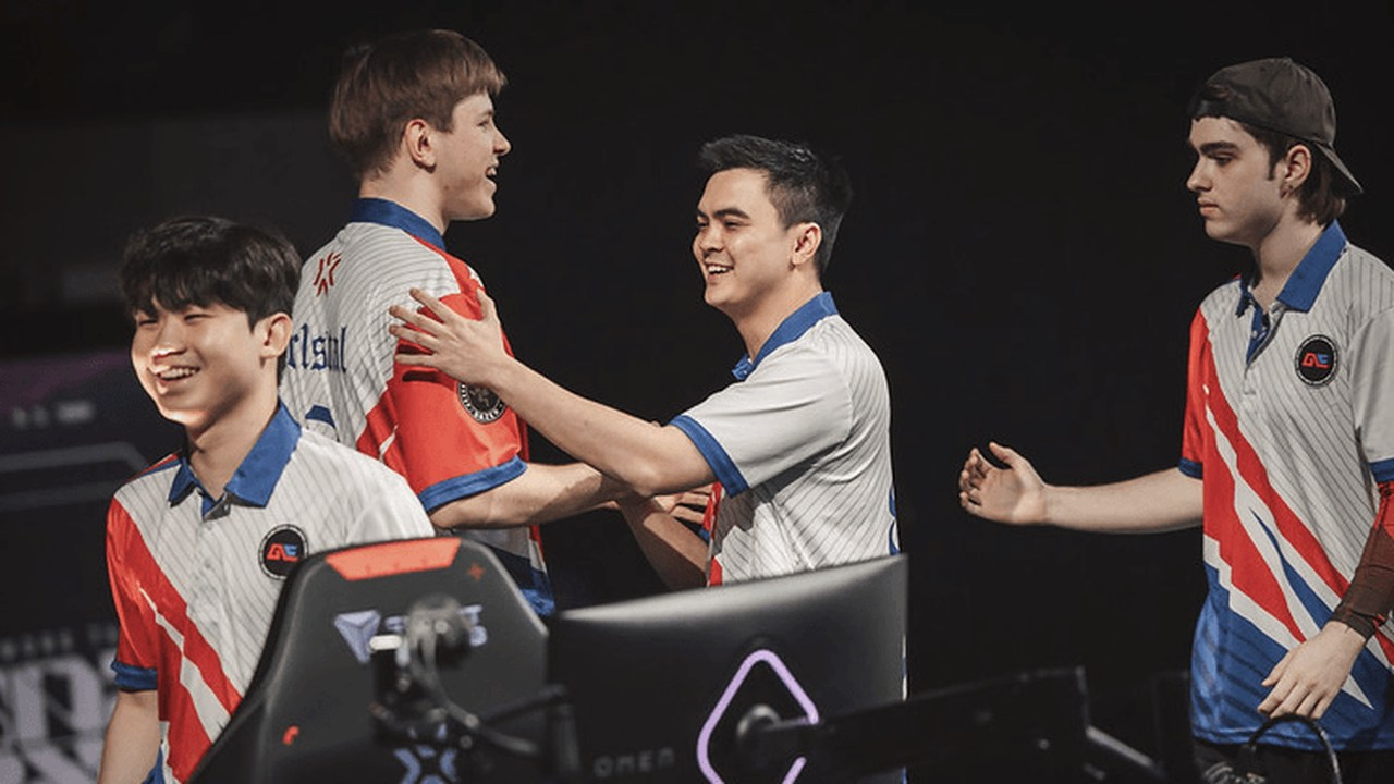 Four Global Esports players celebrate beside their gaming stations