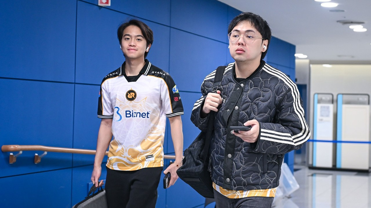 An RRQ player and staff member stand in the tournament venue