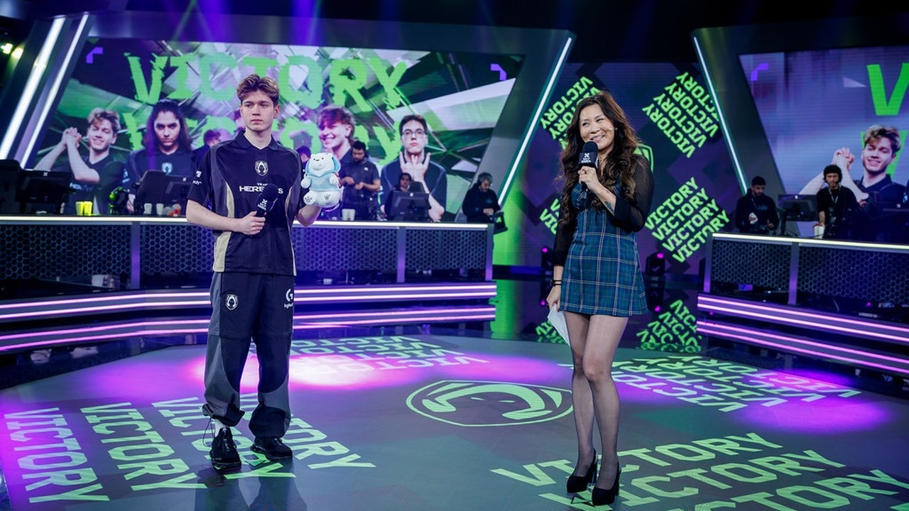 Team Heretics player stands beside a host