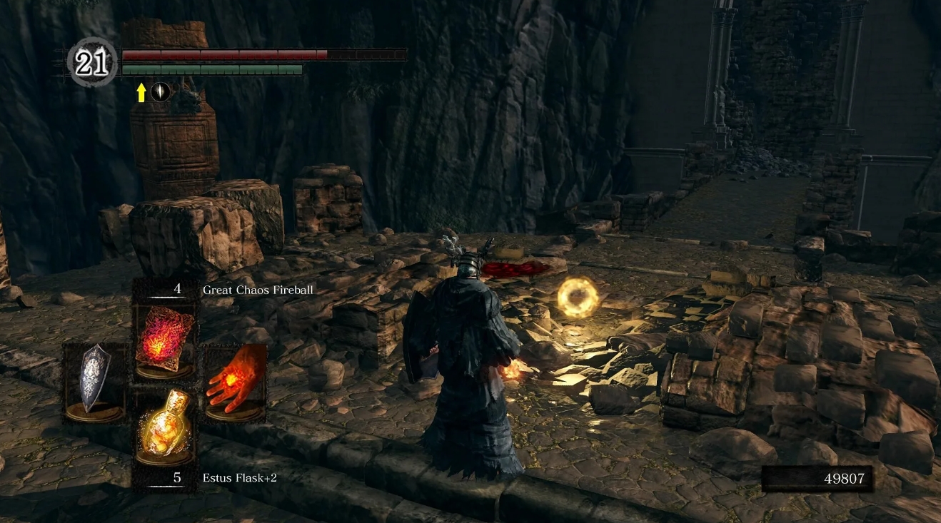Character using fire magic near glowing item loot on rocky terrain in Dark Souls Remastered